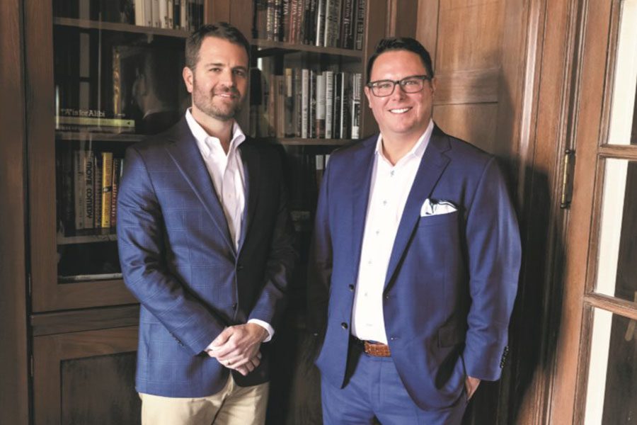 About Our Agency - Business Partners and Owners of Byrne Insurance Group Standing in Front of Bookshelves in the Office