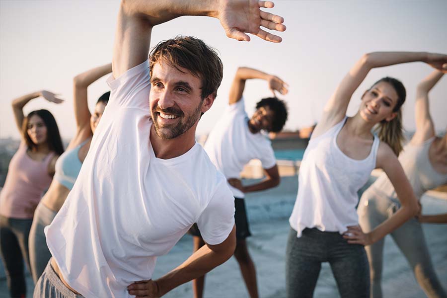 Employee Wellness Program - Employees Performing Their Morning Fitness Routine for a Healthier Lifestyle Outdoors at Sunrise